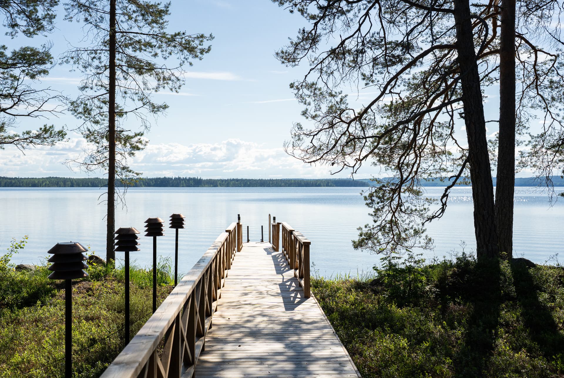 Jetty on a still summer day at Neituri Manor, a private lakeside destination in Finland