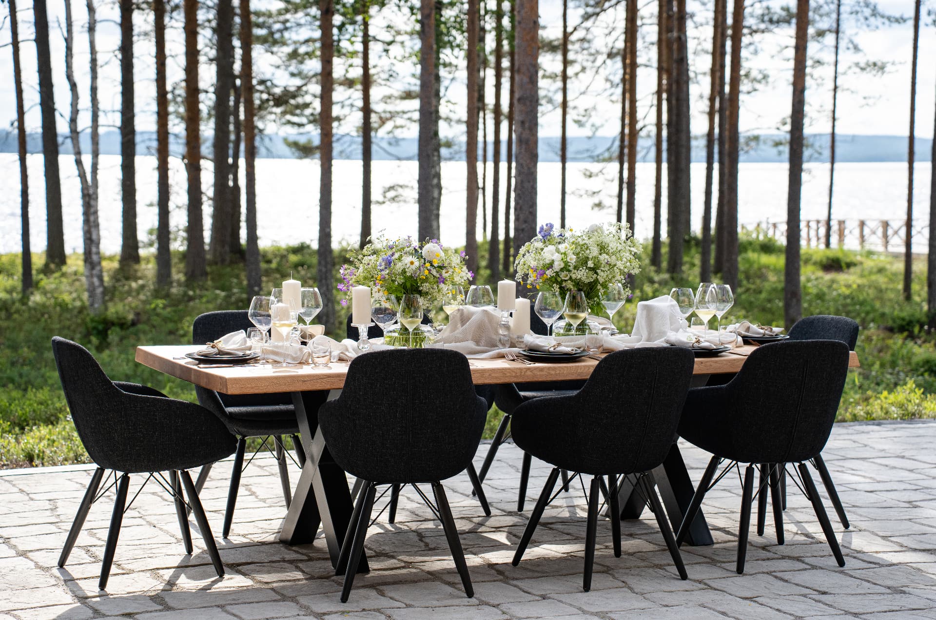 Table set outdoors among the pines for a private celebration at Neituri Manor in Finland