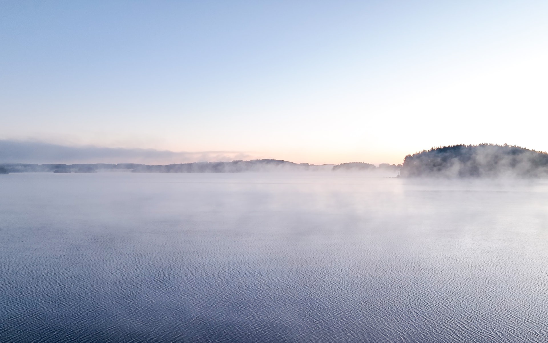 Mist rising over the lake at dawn after a sauna evening at Neituri Manor, Konnevesi