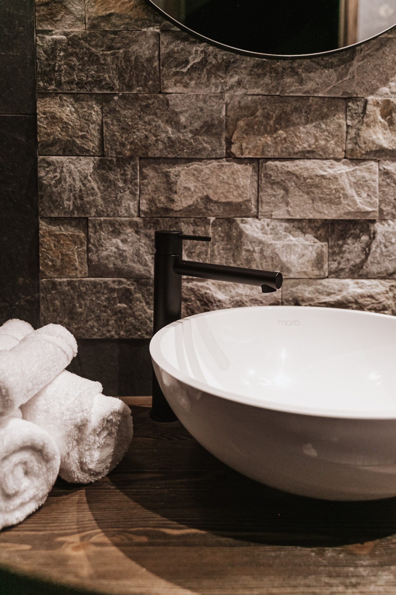 Rolled towels beside the stone basin in a guest bathroom at Neituri Manor