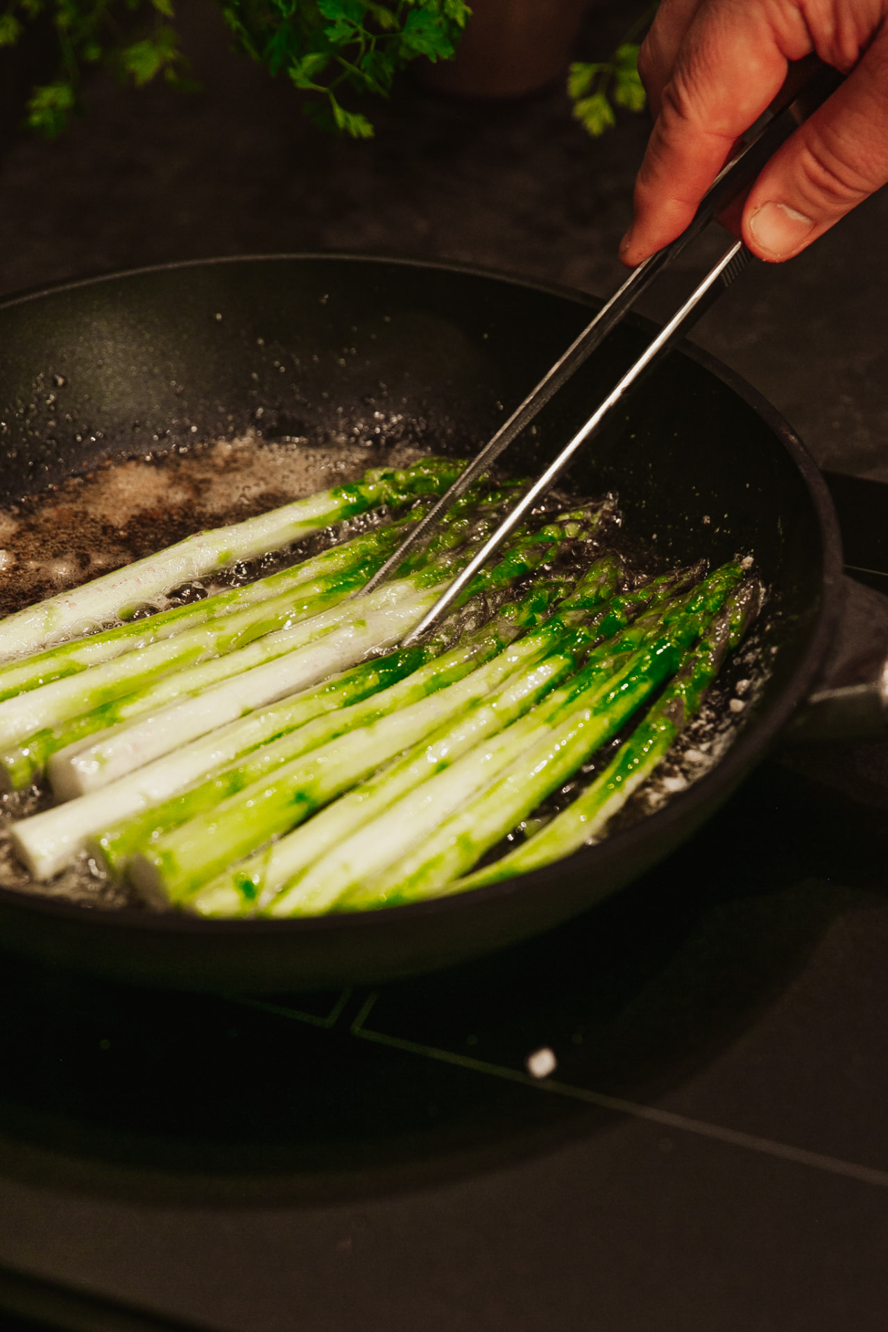 Asparagus turning in butter in the pan in the manor kitchen at Neituri Manor